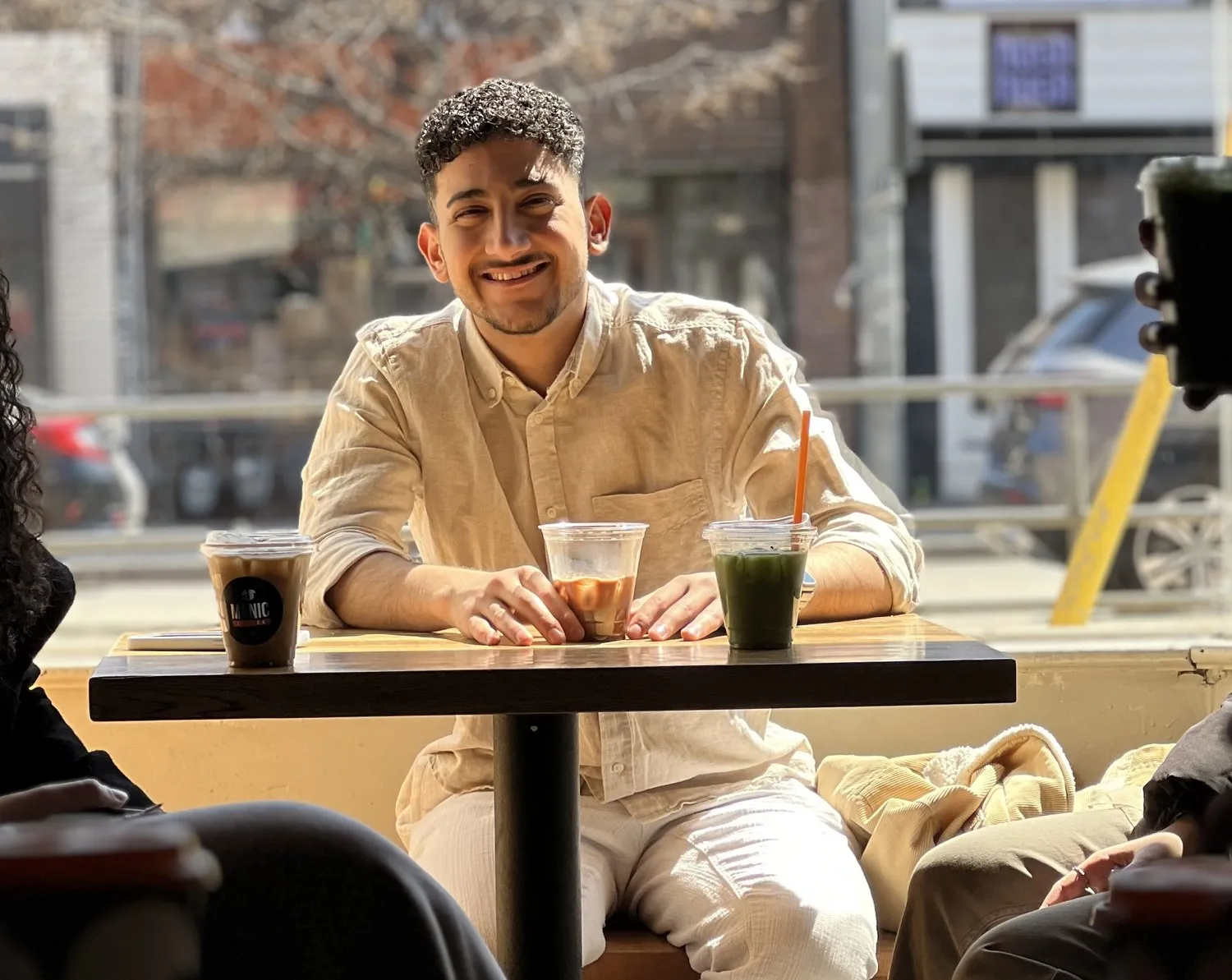 Youssef sitting at a café table in the sun